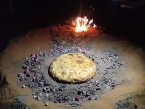 a pizza is cooking in a fire oven at Tazoult Ouzina in Ouzina
