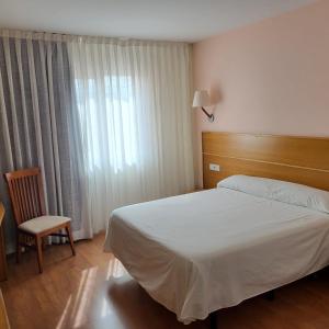 a bedroom with a bed and a chair and a window at Hotel Torcal in Guadalajara +27 photos