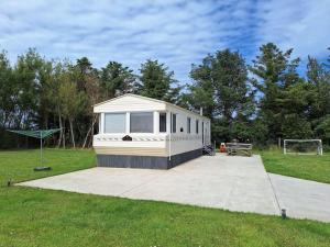 a small white trailer in a field with a goal at Seacoast Caravan Benone in Castlerock
