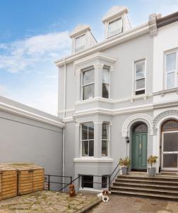 a white house with two dogs sitting in front of it at NEW LUXURY for 2024 - Central Plymouth House - Sleeps 10 - Access to Plymouth Town - Close to The Barbican - Pets welcome - Parking Available - By Luxe Living by Sophia in Plymouth