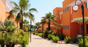 una calle con palmeras y un edificio en Baiamalva Resort Spa en Porto Cesareo