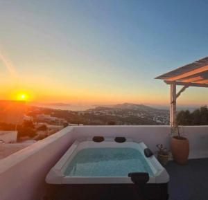 bañera de hidromasaje en la azotea de una casa con puesta de sol en Karpimo North - Sunset view - Private Jacuzzi - up to 4pp, en Fira