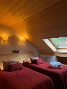 Un dormitorio con dos camas con sábanas rojas y una ventana. en Hôtel et appart'hôtel de l'Hermitage, en Thônes 92 fotos más