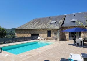 a villa with a swimming pool in front of a building at Le domaine de La Combarsou in Sainte-Féréole