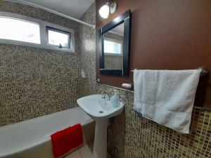 une salle de bain avec un lavabo, une baignoire et un miroir dans l'établissement Cómodo y moderno departamento con cochera, a pasos de la principal calle comercial de la ciudad, à La Plata