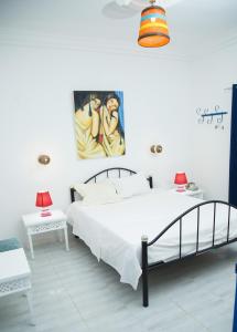 a bedroom with a bed and a painting on the wall at Dar Amazigh in Tozeur