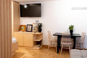 a living room with a table and a tv at Luxury studio 12-4 in Plovdiv