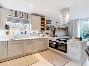 a kitchen with white cabinets and a sink at Boutique Family Stay in the Heart of Surrey - Pass the Keys in Leatherhead