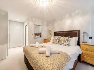a bedroom with a large bed with towels on it at Pass the Keys Spacious Family Oasis Explore with Ease in Leatherhead