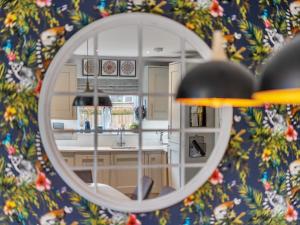 a mirror reflection of a kitchen with a sink and a table at Boutique Family Stay in the Heart of Surrey - Pass the Keys in Leatherhead