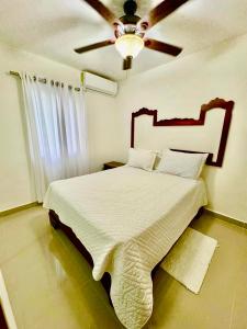 Un dormitorio con una cama grande con ventilador de techo. en Nice apartment in punca cana near the airport and beaches, en Punta Cana