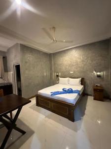 a bedroom with a bed with a blue ribbon on it at Villa Secret Stream in Mirissa +10 photos