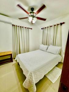 Un dormitorio con una cama con ventilador de techo. en Nice apartment in punca cana near the airport and beaches, en Punta Cana