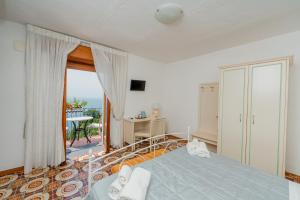 a bedroom with a bed and a balcony at Albergo Diffuso Bacco Furore in Furore