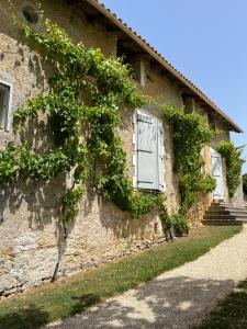 a building with ivy growing on the side of it at Le Gîte de Marie in Saint-Front-la-Rivière