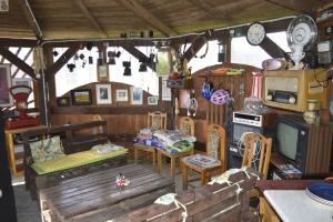 a living room with wooden furniture and a kitchen at Mały Biały Domek in Darłowo