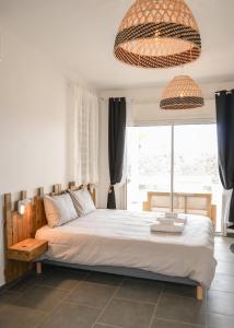 a bedroom with a bed and a large window at La villa Grand Bois avec sa piscine chauffée in Saint-Pierre