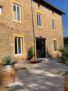 a brick building with a black door and some plants at Gîte Domaine du Berret 8 pers in Bully