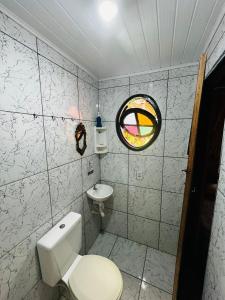 a bathroom with a toilet and a sink at Chalés Recanto da Aldeia in Itanhaém