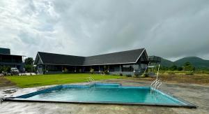 a house with a swimming pool in front of a building at Ettan Stays in Wādhiware