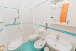 a white bathroom with a sink and a toilet at Albergo Diffuso Bacco Furore in Furore