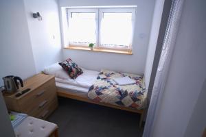 une petite chambre avec un lit et une fenêtre dans l'établissement Pokój jednoosobowy, à Zakopane