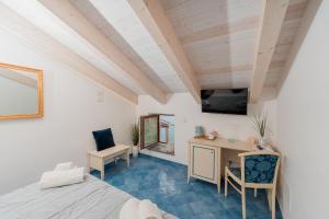 a room with a bed and a desk and a tv at Albergo Diffuso Bacco Furore in Furore