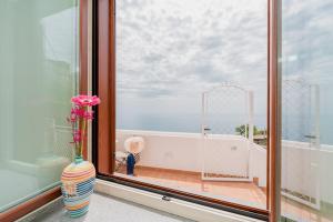 a vase with flowers sitting on a window sill at Albergo Diffuso Bacco Furore in Furore