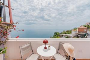 a table and chairs on a balcony with a view of the ocean at Albergo Diffuso Bacco Furore in Furore
