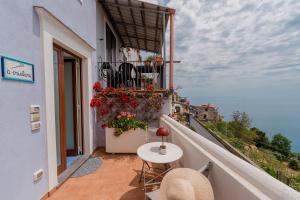 a balcony of a building with a table and flowers at Albergo Diffuso Bacco Furore in Furore