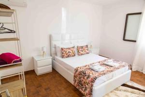 ein weißes Schlafzimmer mit einem Bett und einer Leiter in der Unterkunft Casa Castor Gerês in Geres