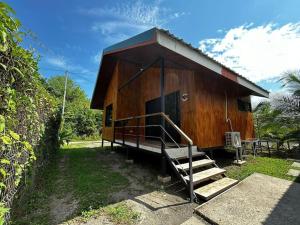 a small wooden cabin with a staircase leading to it at Cabinas Guacamaya Cabuya - 2 cuartos in Cabuya