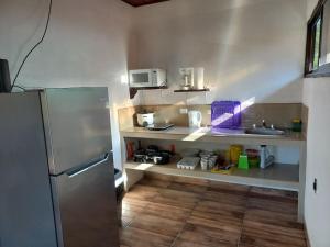 a kitchen with a stainless steel refrigerator and a sink at Cabinas Guacamaya Cabuya - 2 cuartos in Cabuya
