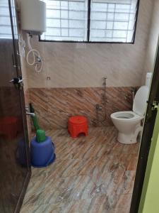 a bathroom with a toilet and a shower in it at Relax stay in Belgaum