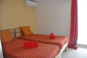 two beds with red pillows in a room at Sublime appartement pour 4pers - Clim - Vue mer - Parking in Les Trois-Îlets