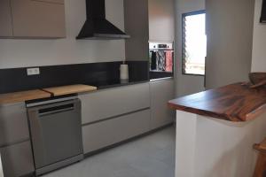 a kitchen with a stove and a counter top at Sublime appartement pour 4pers - Clim - Vue mer - Parking in Les Trois-Îlets