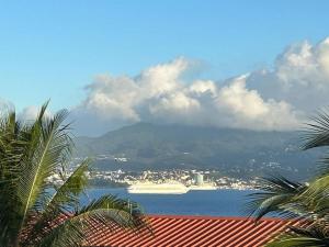 a cruise ship in the water with a mountain at Sublime appartement pour 4pers - Clim - Vue mer - Parking in Les Trois-Îlets