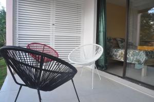 two chairs and a table on a porch at Sublime appartement pour 4pers - Clim - Vue mer - Parking in Les Trois-Îlets