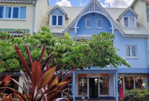 a blue building with a pointed roof at Sublime appartement pour 4pers - Clim - Vue mer - Parking in Les Trois-Îlets