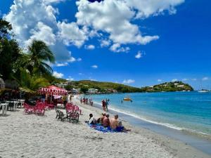 a group of people sitting on a beach at Sublime appartement pour 4pers - Clim - Vue mer - Parking in Les Trois-Îlets