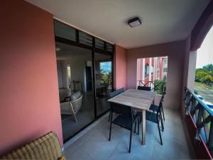a dining room with a table and chairs on a balcony at Sublime appartement pour 4pers - Clim - Vue mer - Parking in Les Trois-Îlets