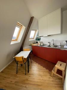 a kitchen with red cabinets and a table in it at Studio Victoria - Centre de Paris in Paris +4 photos