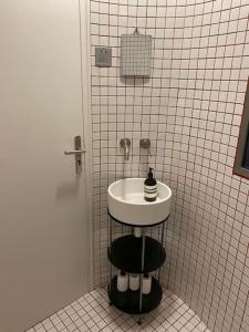 a bathroom with a sink in a tiled wall at Studio Victoria - Centre de Paris in Paris
