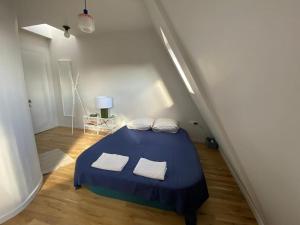 a bedroom with a blue bed with two white towels at Studio Victoria - Centre de Paris in Paris