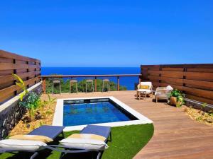 a swimming pool on a deck with the ocean in the background at Villa Bo'M Bleue in Petite Île