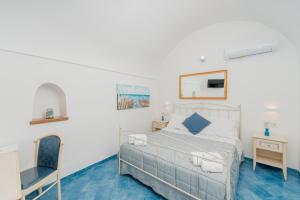 a bedroom with a bed and a chair at Albergo Diffuso Bacco Furore in Furore +37 photos