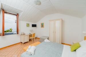 a bedroom with a bed and a desk and a window at Albergo Diffuso Bacco Furore in Furore