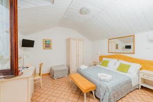 a bedroom with a bed and a desk and a television at Albergo Diffuso Bacco Furore in Furore