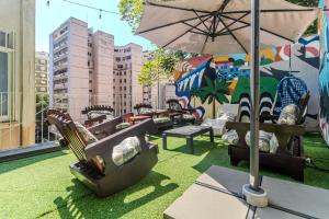 a patio with chairs and an umbrella on the grass at Maroca RIO in Rio de Janeiro