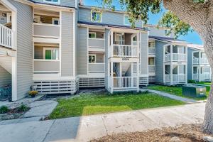 a apartment building with balconies and a yard at Mariners Cay 40 in Folly Beach